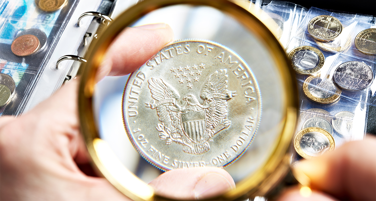 Certified coin viewed with a magnifying glass